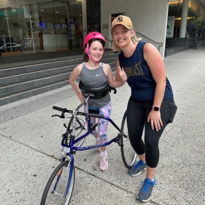 Young girl on running frame with mother standing beside her. Image, UQ